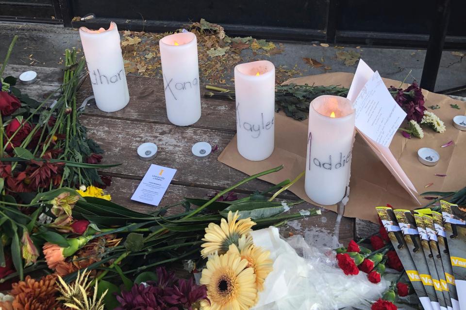 Candles and flowers are left at a make-shift memorial honoring four slain University of Idaho students outside the Mad Greek restaurant in downtown Moscow, Idaho, on Tuesday, Nov. 15, 2022.