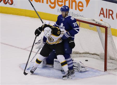 Apr 3, 2014; Toronto, Ontario, CAN; A shot by Boston Bruins forward Patrice Bergeron (not pictured) gets through forward Loui Eriksson (21) and Toronto Maple Leafs defenseman Carl Gunnarsson (36) and goaltender James Reimer (34) to score in the third period at the Air Canada Centre. Toronto defeated Boston 4-3 in overtime. Mandatory Credit: John E. Sokolowski-USA TODAY Sports