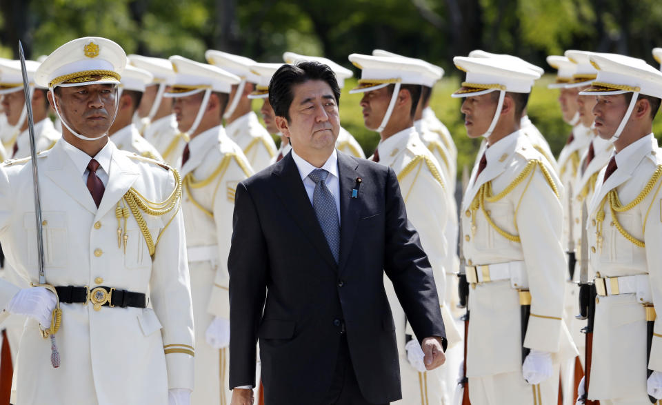 FILE - Then Japanese Prime Minister Shinzo Abe, center, reviews an honor guard in a ceremony prior to his meeting with high-ranked officers of the Japan Self-Defense Forces at the Defense Ministry in Tokyo on Sept. 12, 2013. Former Japanese Prime Minister Abe, a divisive arch-conservative and one of his nation's most powerful and influential figures, has died after being shot during a campaign speech Friday, July 8, 2022, in western Japan, hospital officials said.(AP Photo/Koji Sasahara, File)