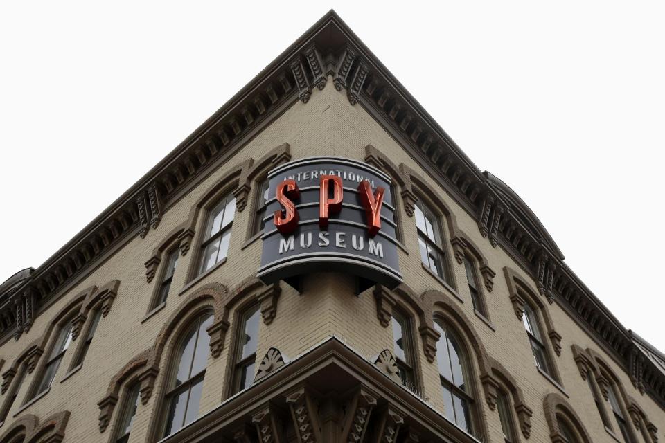 A sign for the International Spy Museum is lit up around the corner from the Adams Building which currently houses the museum, in Washington, Monday, Sept. 23, 2013. The museum, one of the hottest attractions in the nation’s capital over the past decade, is considering a move to a historic library that would give it more space for exhibits and a link to the city’s convention center. (AP Photo/Jacquelyn Martin)