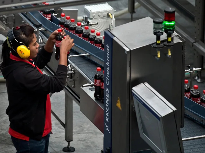 An attendant checks bottles on a production line at the Coca-Cola bottling plant in Nilai on the outskirts of Kuala Lumpur.