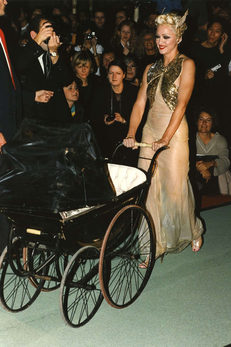 <p>Making a runway appearance for Jean Paul Gaultier, Madonna hit the catwalk in a sheer, gold embellished gown while pushing a baby carriage. </p>