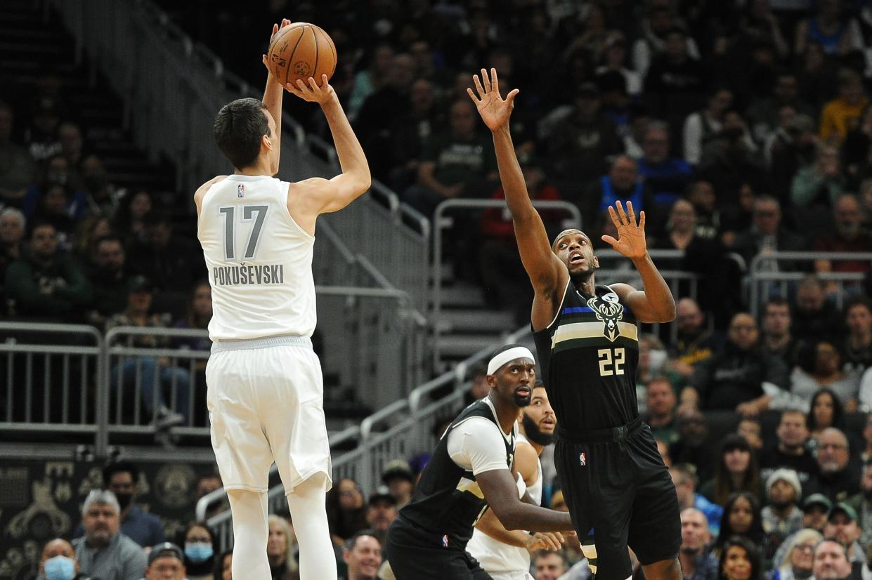 Nov 19, 2021; Milwaukee, Wisconsin, USA;  Oklahoma City Thunder forward Aleksej Pokusevski (17) puts up a shot against Milwaukee Bucks forward Khris Middleton (22) in the second half at Fiserv Forum. Final Milwaukee Bucks 96, Oklahoma City Thunder 89. Mandatory Credit: Michael McLoone-USA TODAY Sports