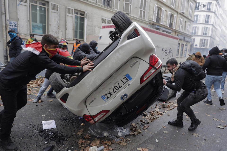 12月24日，法國上千人上街抗議槍擊事件，有抗議者將汽車推翻。   圖：達志影像／美聯社
