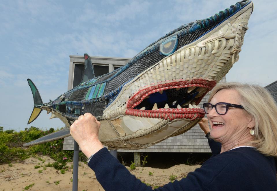 Artist Cindy Pease Roe beside her shark called "Mama Shug" made entirely of washed-up marine plastic trash. The sculpture was unveiled at Herring Cove Beach in Provincetown on Thursday, World Ocean Day.