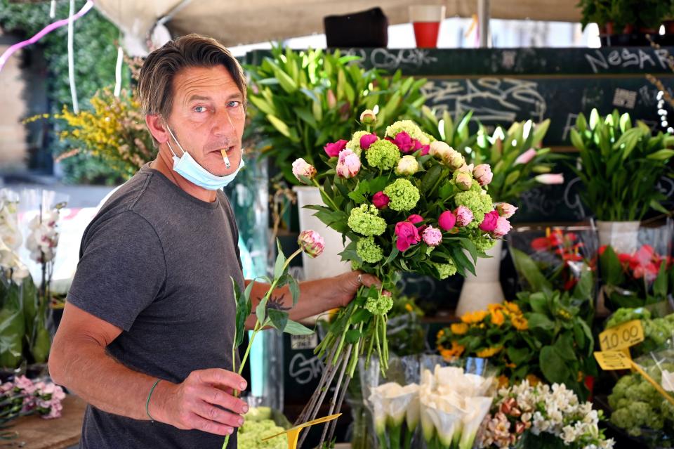 A flower seller poses on May 5, 2020 in central Rome, during the country's lockdown aimed at curbing the spread of the COVID-19 infection, caused by the novel coronavirus. (Photo by Alberto PIZZOLI / AFP) (Photo by ALBERTO PIZZOLI/AFP via Getty Images)