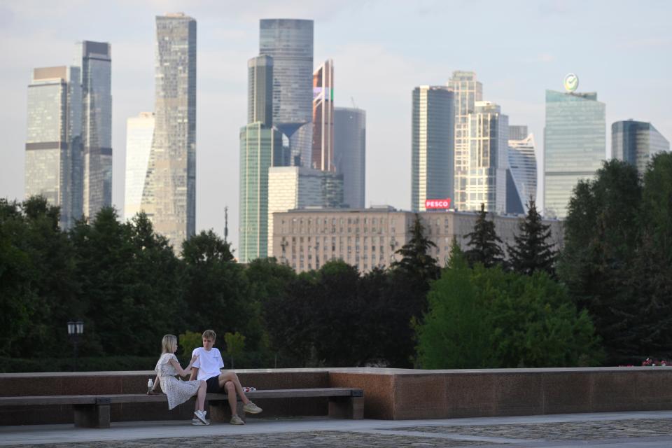 A couple sit in a park in Moscow with the 