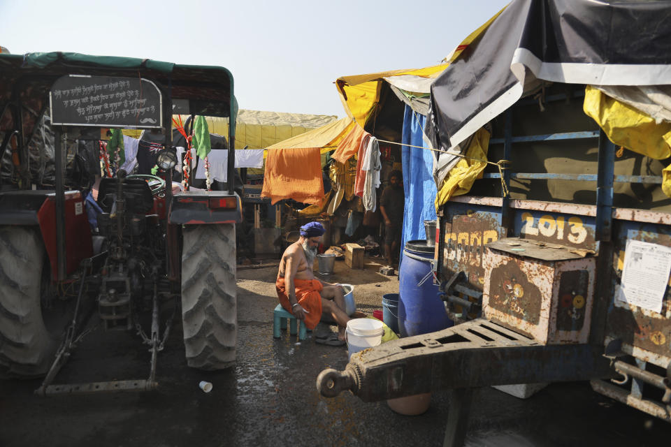 A Sikh farmer takes a wash at his makeshift tent at Singhu, Delhi-Haryana border camp for protesting farmers against three farm bills, in New Delhi, India, Wednesday, Jan. 27, 2021. Leaders of a protest movement sought Wednesday to distance themselves from a day of violence when thousands of farmers stormed India's historic Red Fort, the most dramatic moment in two months of demonstrations that have grown into a major challenge of Prime Minister Narendra Modi’s government. (AP Photo/Manish Swarup)