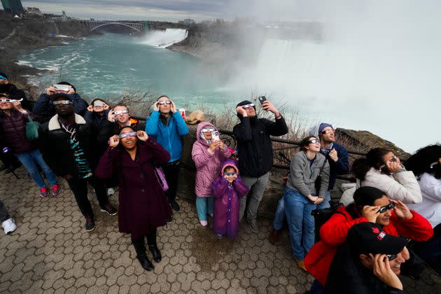 People gather to watch the total solar eclipse from Niagara Falls, Ontario, Monday, April 8, 2024. (AP Photo/Matt Rourke)