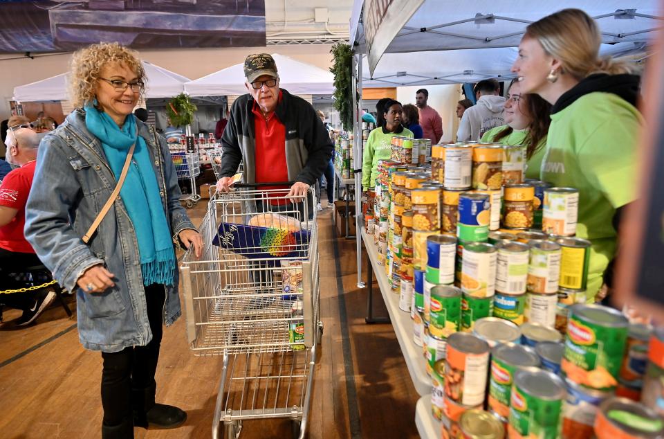 Vietnam War veteran John Sulham, 76, of Millbury, makes his way down the line with Fallon Healthcare volunteer Sharon Nolli, of Shrewsbury, during Veterans Inc.'s annual Holiday Harvest Tuesday.