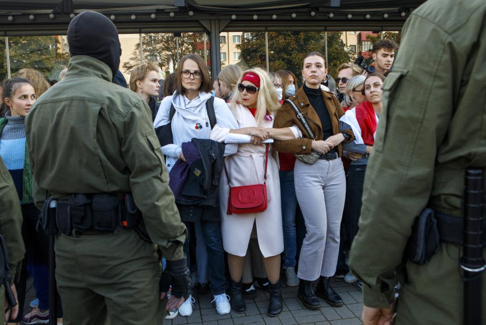 Women stand holding hands in front of police officers during an opposition rally to protest the official presidential election results in Minsk, Belarus, Saturday, Sept. 19, 2020. Police in the capital of Belarus cracked down sharply Saturday on a women's protest march demanding the authoritarian president's resignation, arresting more than 200 including an elderly woman who has become a symbol of the six weeks of protest that have roiled the country. (AP Photo)