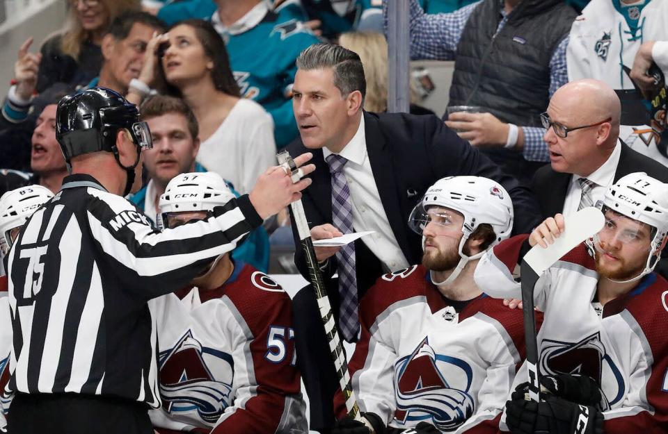 Colorado Avalanche head coach Jared Bednar, center, talks with an official after a goal by Colin Wilson was called back for a penalty during the second period of Game 7 of an NHL hockey second-round playoff series against the San Jose Sharks in San Jose, Calif., Wednesday, May 8, 2019. (AP Photo/Josie Lepe)
