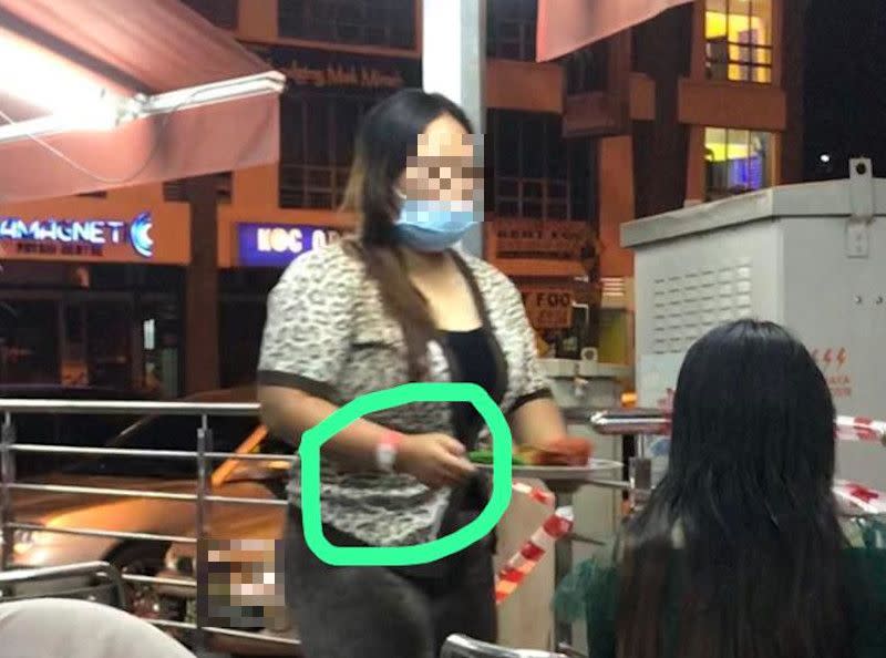 Picture of a woman sporting the pink Person Under Surveillance for Covid-19 wristband and dining out at a restaurant said to be in Ipoh, Perak were shared online today. — Picture from social media