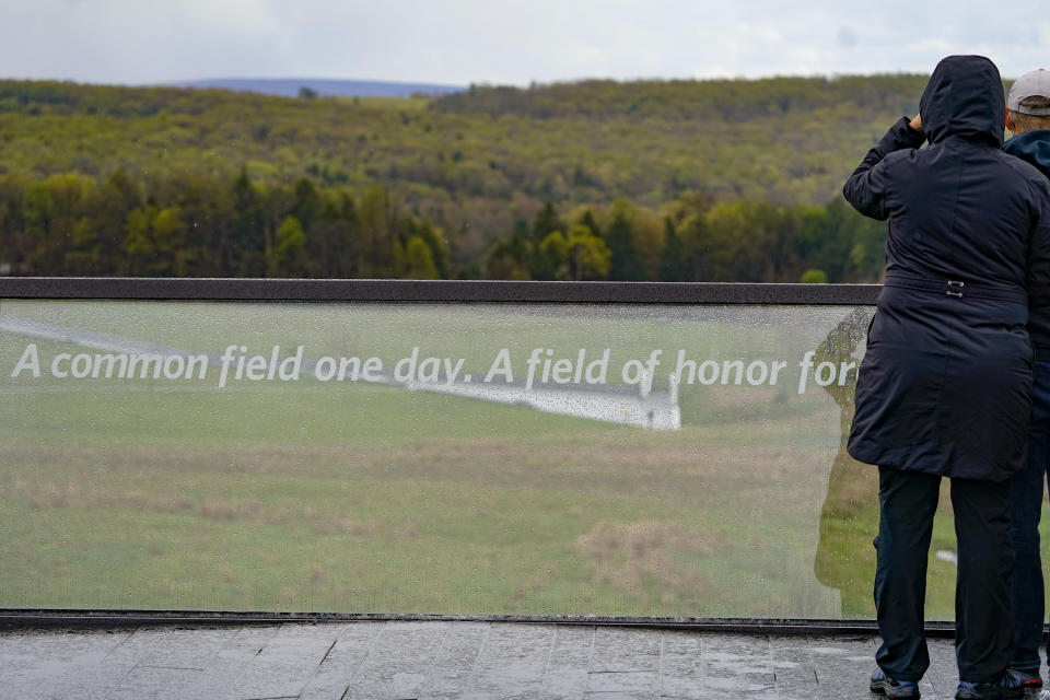 Visitors look from the observation deck at the visitors center of the Flight 93 National Memorial to the field of the crash site and Wall of Names of the people that perished there, Saturday, May 8, 2021, in Shanksville, Pa. The organization "Friends of Flight 93" is creating a new annual award for heroism that aims to reward selfless acts of heroism, but also to educate the public on what happened when those aboard hijacked Flight 93, learned of the attacks that had just occurred in New York and Washington D.C. The passengers and crew then tried to wrest control of the aircraft they were on, which crashed into a field, leaving no survivors. (AP Photo/Keith Srakocic)