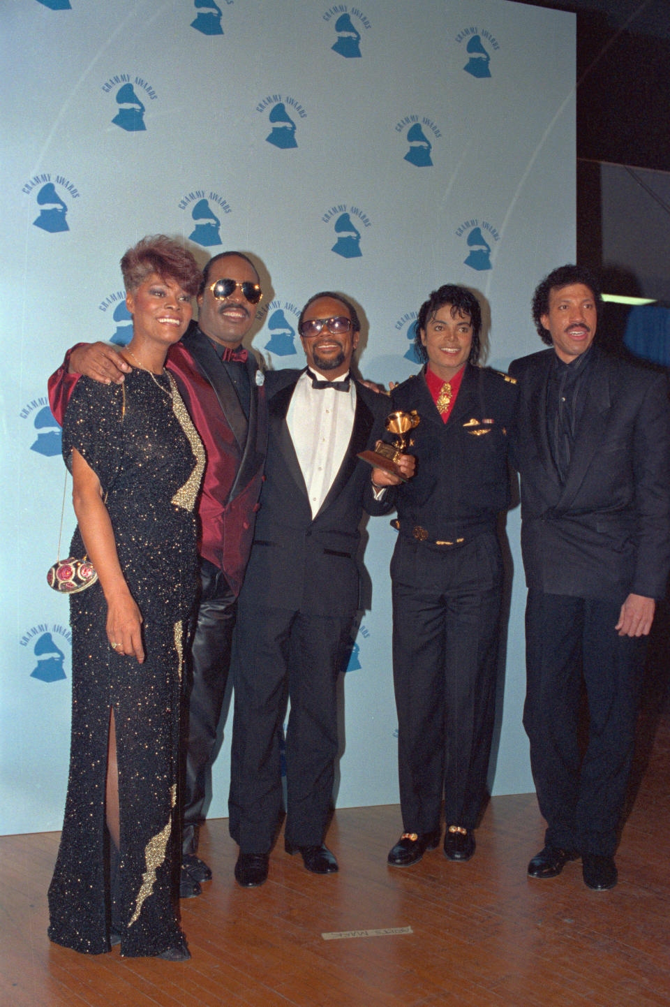 (Original Caption) Los Angeles: Left to right Dionne Warwick, Stevie Wonder, Quincy Jones, Michael Jackson and Lionel Ritchie pose with the grammy they received for their performances on the all-star recording "We are the World."