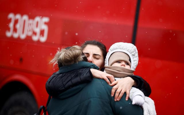 People fleeing Russian invasion of Ukraine hug each other at a temporary camp in Przemysl, Poland -  YARA NARDI/ REUTERS