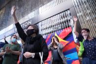 Office workers shout slogans as they attend a lunchtime anti-government protest in the Central district of Hong Kong