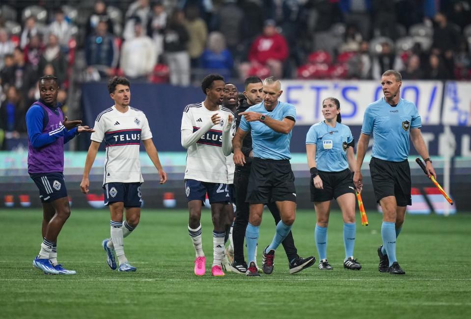 Referee Tim Ford, centre right, is followed by Whitecaps' Ali Ahmed, centre left, and Sam Adekugbe, back left, as he leaves the field after Vancouver's 1-0 home loss to Los Angeles FC in Game 2 of their first-round MLS playoff series on Sunday.