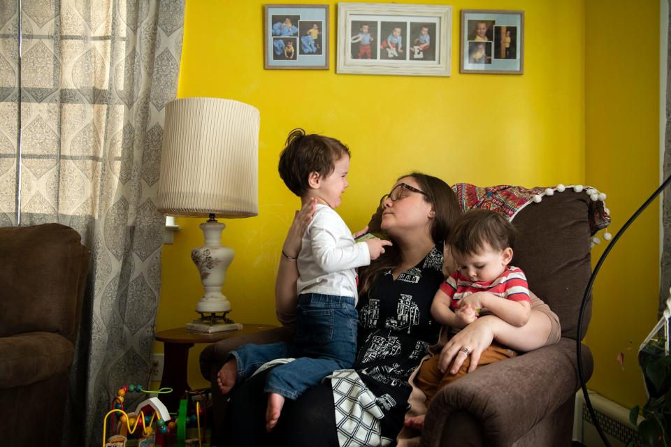 Katherine Hart consoles her 3-year-old son, while holding his younger sibling at their home in Medford Lakes, NJ.