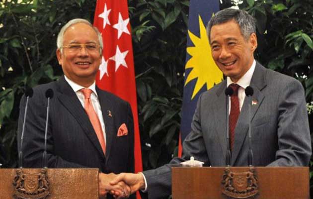 Singapore Prime Minister Lee Hsien Loong (R) shakes hands with his Malaysian counterpart Najib Razak (L) after their joint press conference in Singapore on September 20, 2010. (AFP PHOTO/ROSLAN RAHMAN)