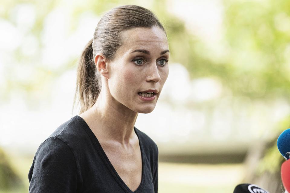 Finnish Prime Minister Sanna Marin, wearing a ponytail, speaks in an outdoor setting.