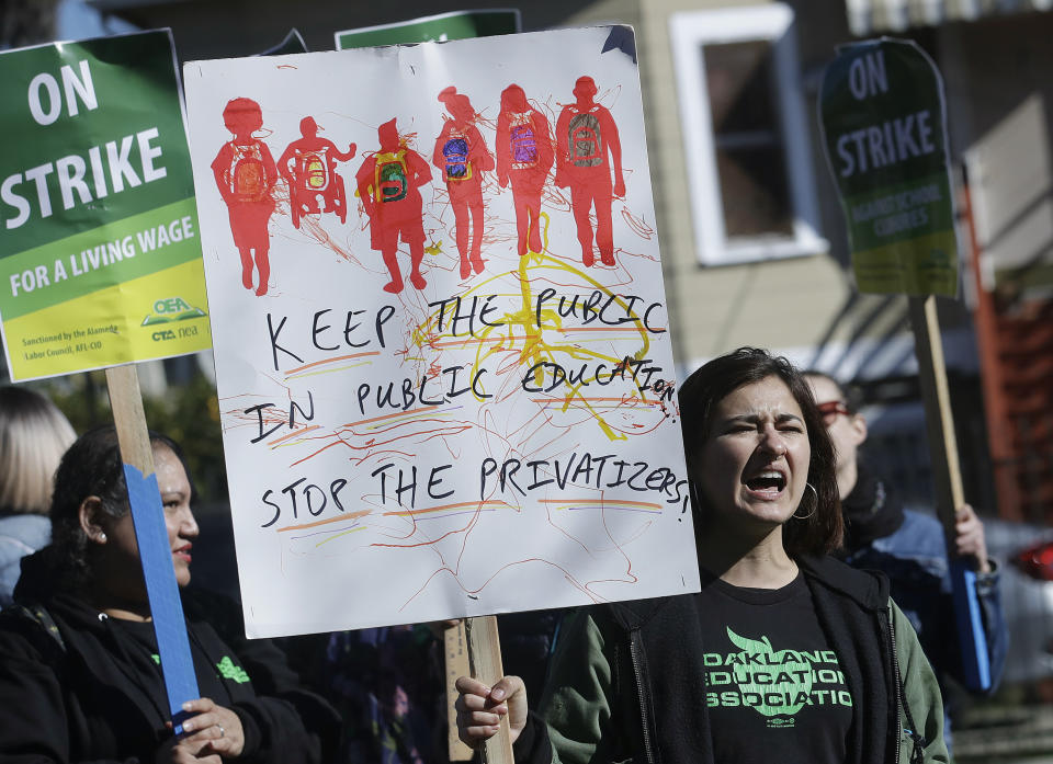 Teacher Estefana Ramos yells with teachers, parents and supporters outside of Manzanita Community School in Oakland, Calif., Thursday, Feb. 21, 2019. Teachers in Oakland, California, went on strike Thursday in the country's latest walkout by educators over classroom conditions and pay. (AP Photo/Jeff Chiu)