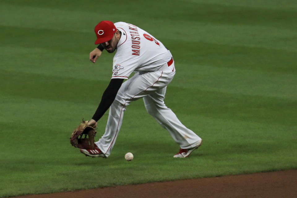 Cincinnati Reds' Mike Moustakas fields the ball after Chicago White Sox's Jose Abreu hit for a single in the fourth inning during a baseball game in Cincinnati, Saturday, Sept. 19, 2020. (AP Photo/Aaron Doster)