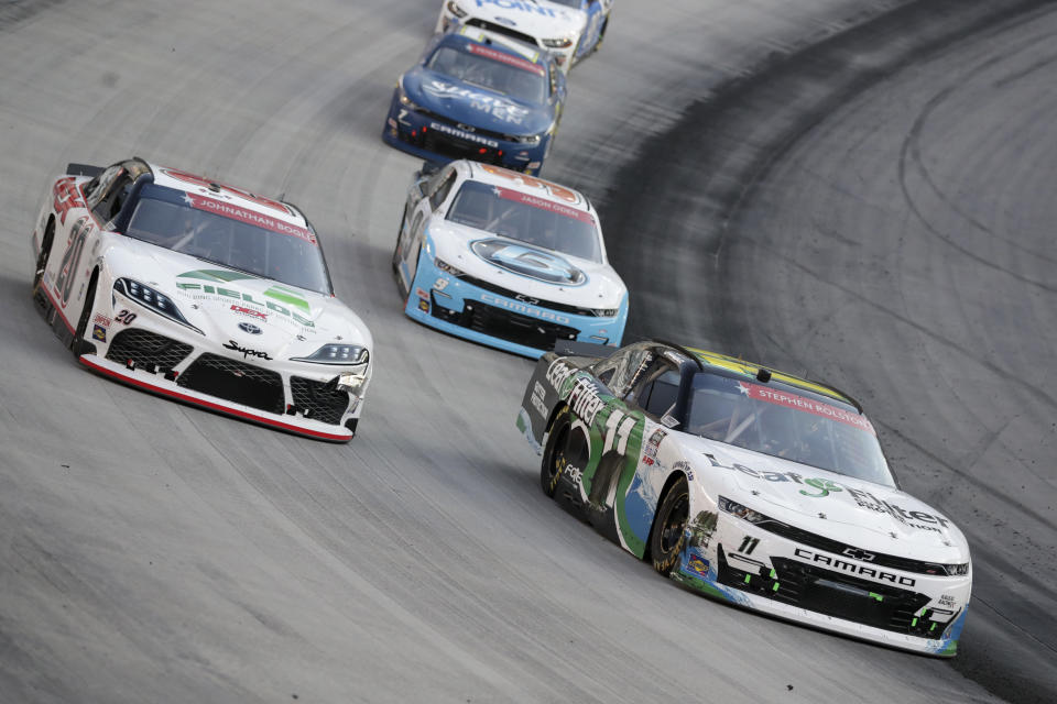 Harrison Burton (20) goes high around Justin Haley (11) during NASCAR Xfinity Series auto race at Bristol Motor Speedway Monday, June 1, 2020, in Bristol, Tenn. (AP Photo/Mark Humphrey)