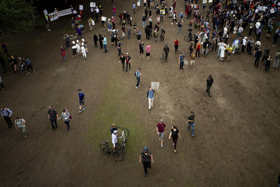 Right-wing demonstrators and counter-protesters gather in Tom McCall Waterfront Park during an "End Domestic Terrorism" rally in Portland, Ore., on Saturday, Aug. 17, 2019. Portland Mayor Ted Wheeler said the situation was "potentially dangerous and volatile" but as of early afternoon most of the right-wing groups had left the area via a downtown bridge and police used officers on bikes and in riot gear to keep black clad, helmet and mask-wearing anti-fascist protesters — known as antifa — from following them. (AP Photo/Noah Berger)