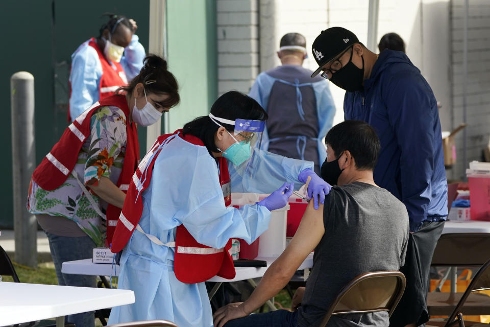 FILE - In this Jan. 13, 2021, file photo, health care workers receive a COVID-19 vaccination at Ritchie Valens Recreation Center, in Pacoima, Calif. California will require all of its roughly 2.2 million health care and long term care workers to be fully vaccinated against the coronavirus by Sept. 30. Gov. Gavin Newsom said last month he would require health care workers to either be vaccinated or submit to weekly testing. (AP Photo/Marcio Jose Sanchez, File)