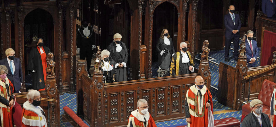 Britain's Prime Minister Boris Johnson, left, Black Rod Sarah Clarke, Speaker of the House of Commons Sir Lindsay Hoyle and Leader of the Opposition Kier Starmer, right, listen as Queen Elizabeth II delivers a speech in the House of Lords at the Palace of Westminster in London, Tuesday May 11, 2021. (Aaron Chown/Pool via AP)