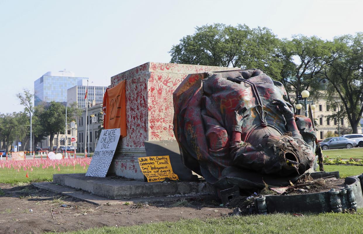 A headless statue of Queen Victoria is seen overturned and vandalized at the provincial legislature in Winnipeg on Friday.