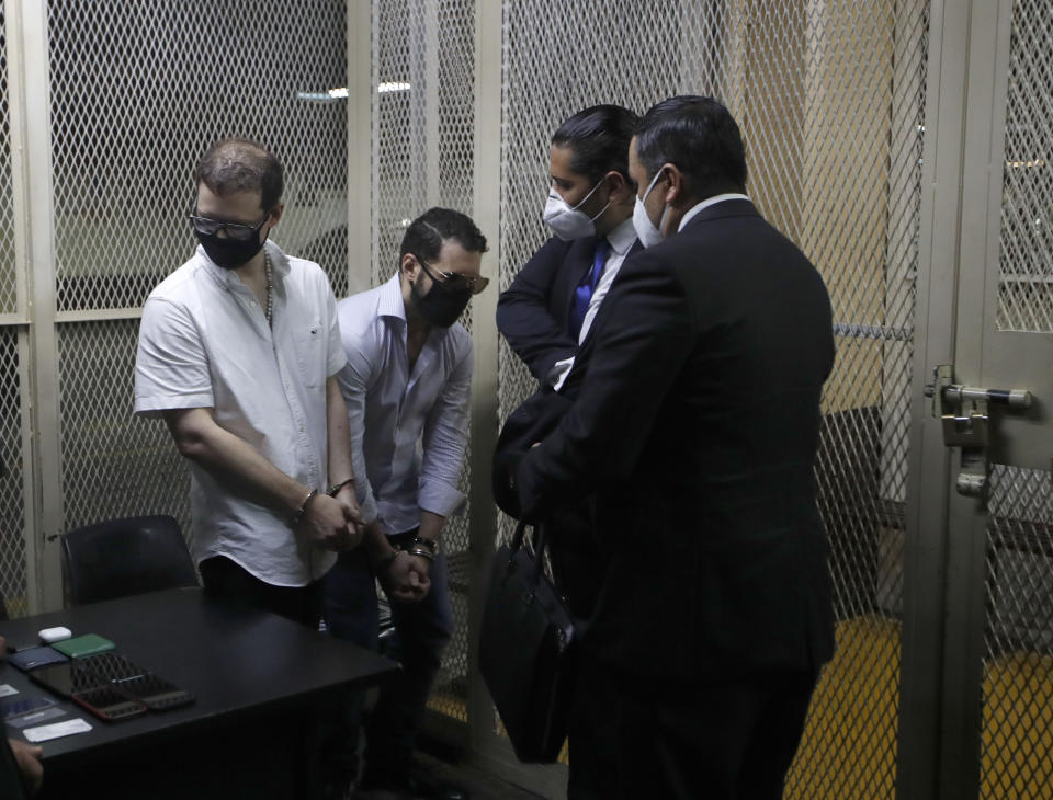 The sons of former Panamenian President Ricardo Martinelli, Ricardo Martnelli Linares, second left, and his brother Luis Enrique Martinelli Linares, left, are accompanied by their lawyers before a hearing at the judicial court building in Guatemala City, Monday, July 6, 2020. Guatemalan police detained the Martinelli brothers on an Interpol warrant for money laundering, as they attempted to board a private plane out of the country. (AP Photo/Moises Castillo)