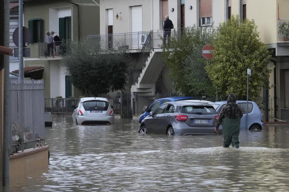 A man makes is way on a flooded street in Campi di Bisenzio, in the central Italian Tuscany region, Friday, Nov. 3, 2023. Record-breaking rain provoked floods in a vast swath of Tuscany as storm Ciaran pushed into Italy overnight Friday, trapping people in their homes, inundating hospitals and overturning cars. At least three people were killed, and four were missing. (AP Photo/Gregorio Borgia)
