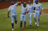 Texas Rangers' Ronald Guzman (11) congratulates Rougned Odor, second from left, for hitting a three-run home run while Nick Solak, second from right, and Joey Gallo, right, look on during the fourth inning of a baseball game against the Houston Astros in Arlington, Texas, Sunday, Sept. 27, 2020. (AP Photo/Roger Steinman)