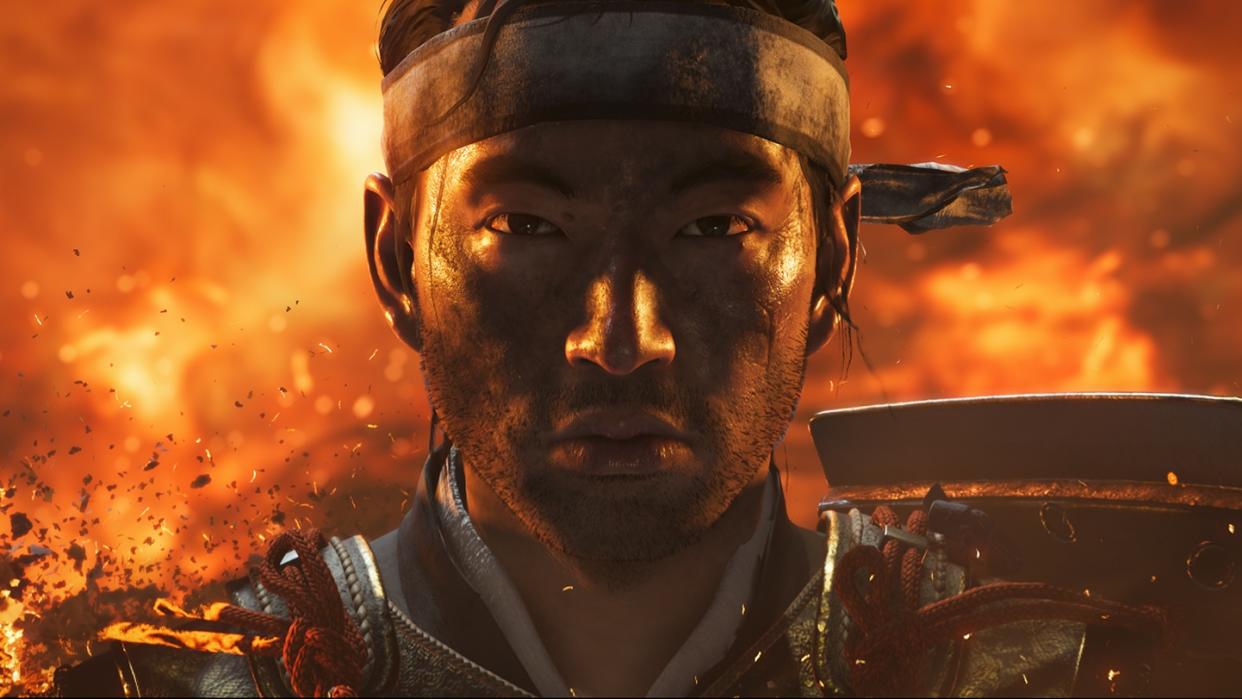  A close-up of Jin from Ghost Tsushima, a raging fire behind him. 