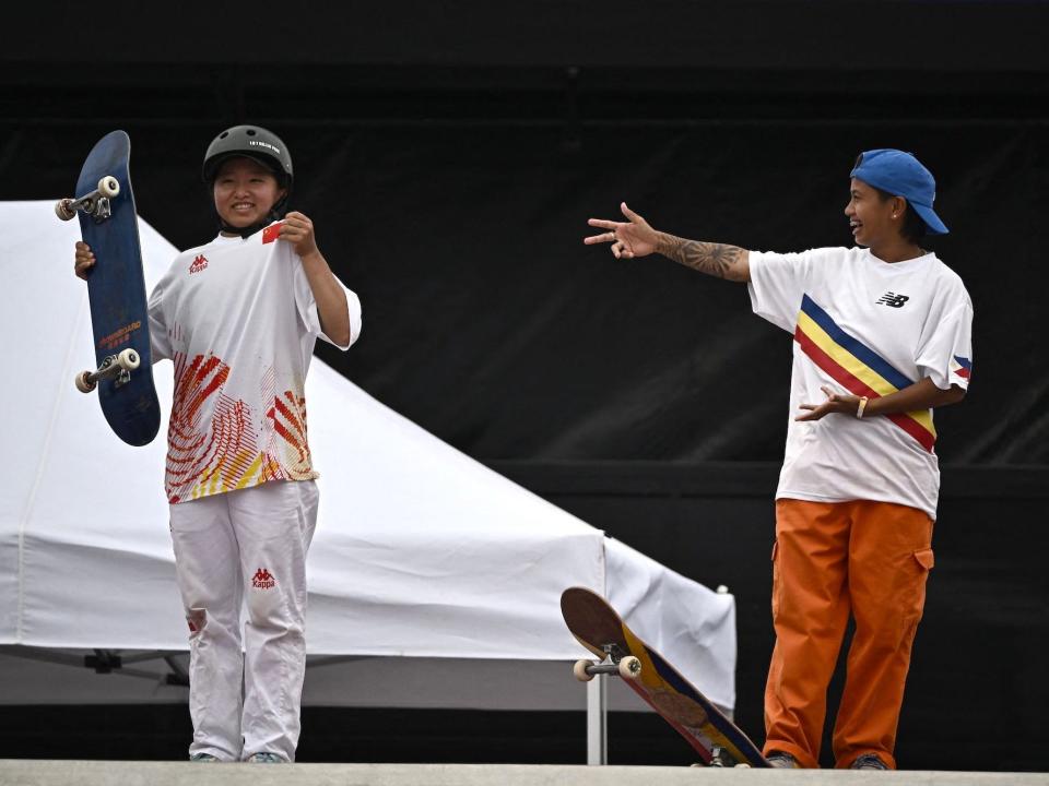 Margielyn Arda Dadal of the Philippines points to China's Zeng Wenhui during the skateboarding women's street final.