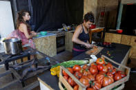 Members of the "Assemblea Cavallerizza 14:45" movement prepare meals that they will sell to visitors at the Cavallerizza Reale building, which is occupied by the movement, in Turin, Italy, July 16, 2016. REUTERS/Marco Bello