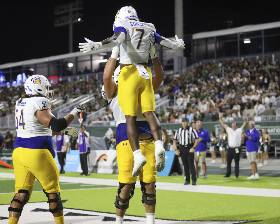 San Jose State offensive lineman Fernando Carmona Jr. (79) lifts running back Quali Conley (7) after a Conley touchdown against Hawaii during the first half of an NCAA college football game Saturday, Oct. 28, 2023, in Honolulu. (AP Photo/Marco Garcia)