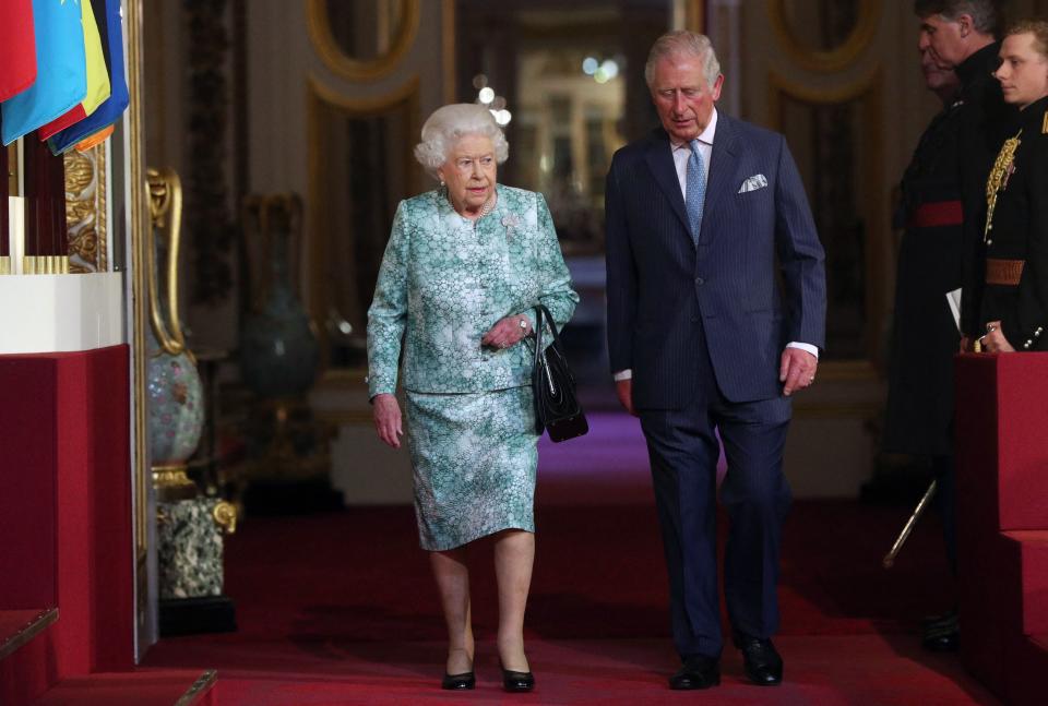 TOPSHOT - Britain's Queen Elizabeth II and Britain's Prince Charles, Prince of Wales arrive for the formal opening of the Commonwealth Heads of Government Meeting (CHOGM), in the ballroom at Buckingham Palace in London on April 19, 2018. (Photo by Jonathan Brady / POOL / AFP) (Photo by JONATHAN BRADY/POOL/AFP via Getty Images)