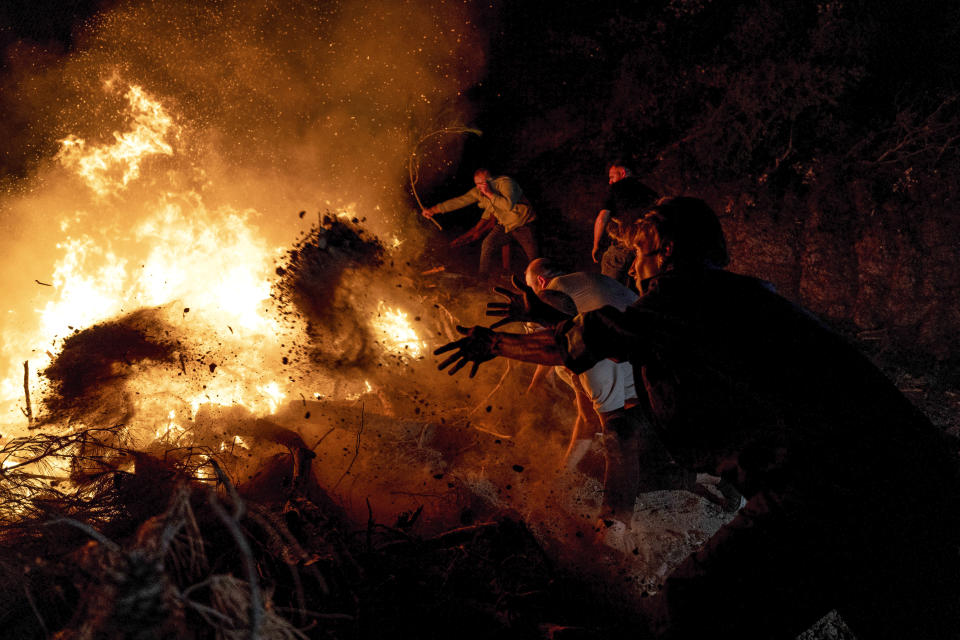 Firefighters and residents try to extinguish a fire in the city of Canakkale, northwest Turkey, Wednesday, Aug. 23, 2023. Authorities evacuated three villages and temporarily closed down a highway as firefighters battled a wildfire, fanned by strong winds, in northwestern Canakkale province. (Ugur Yildirim/dia images via AP)