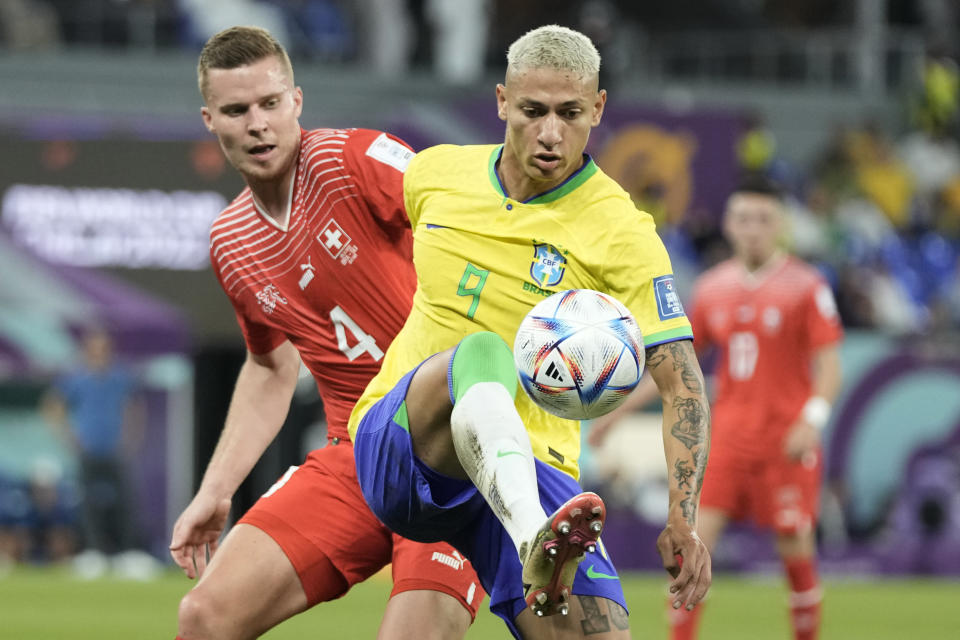 Brazil's Richarlison, centre, and Switzerland's Nico Elvedi challenge for the ball during the World Cup group G soccer match between Brazil and Switzerland at the Stadium 974 in Doha, Qatar, Monday, Nov. 28, 2022. (AP Photo/Hassan Ammar)