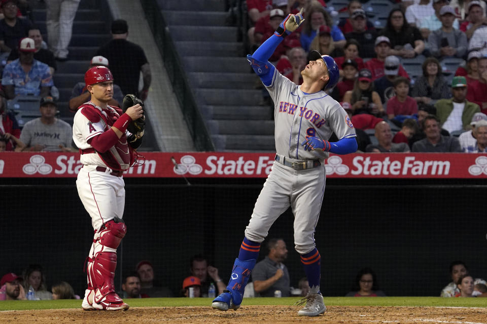 New York Mets' Brandon Nimmo, right, gestures as he scores after hitting a solo home run as Los Angeles Angels catcher Max Stassi stands at the plate during the fourth inning of a baseball game Friday, June 10, 2022, in Anaheim, Calif. (AP Photo/Mark J. Terrill)