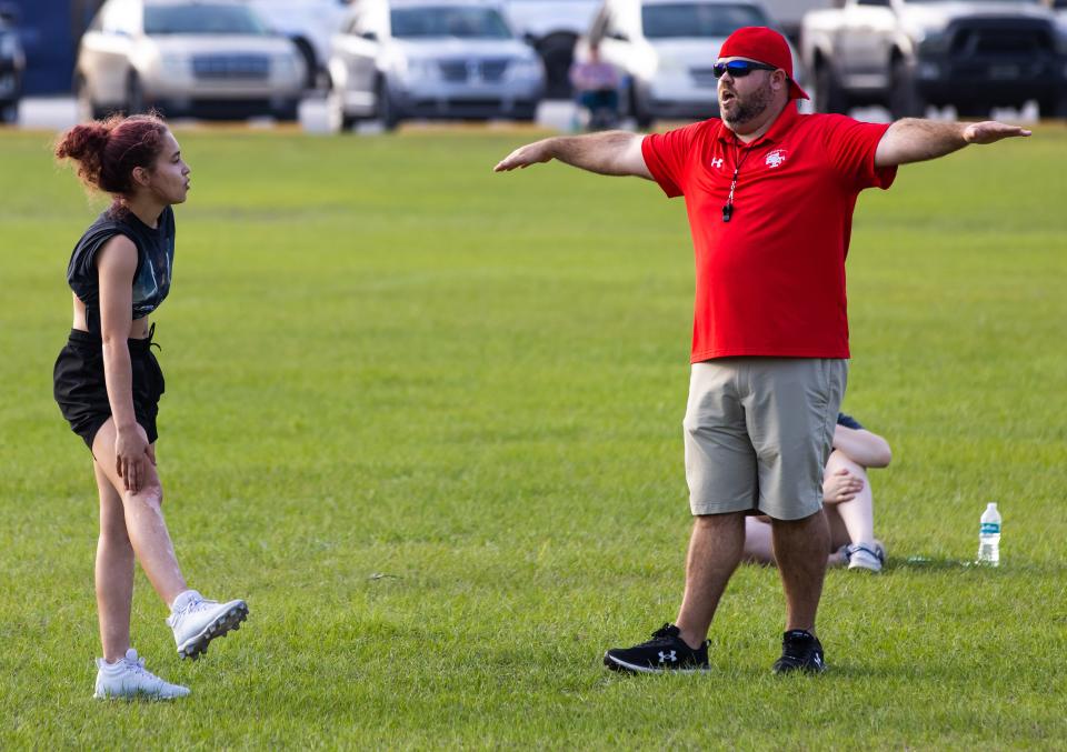 Coach Heath Brannen, right, signals a play as running back Nataliya Williams, left, listens to the play call during Santa Fe flag football practice Tuesday afternoon, February 28, 2023 at the High Springs Civic Center. Santa Fe flag football is in its first season and is the first team in Alachua County.  [Doug Engle/Gainesville Sun]2023