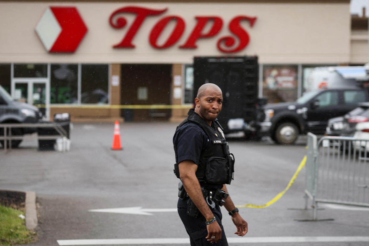 A Buffalo police officer stands in the Tops market parking lot.