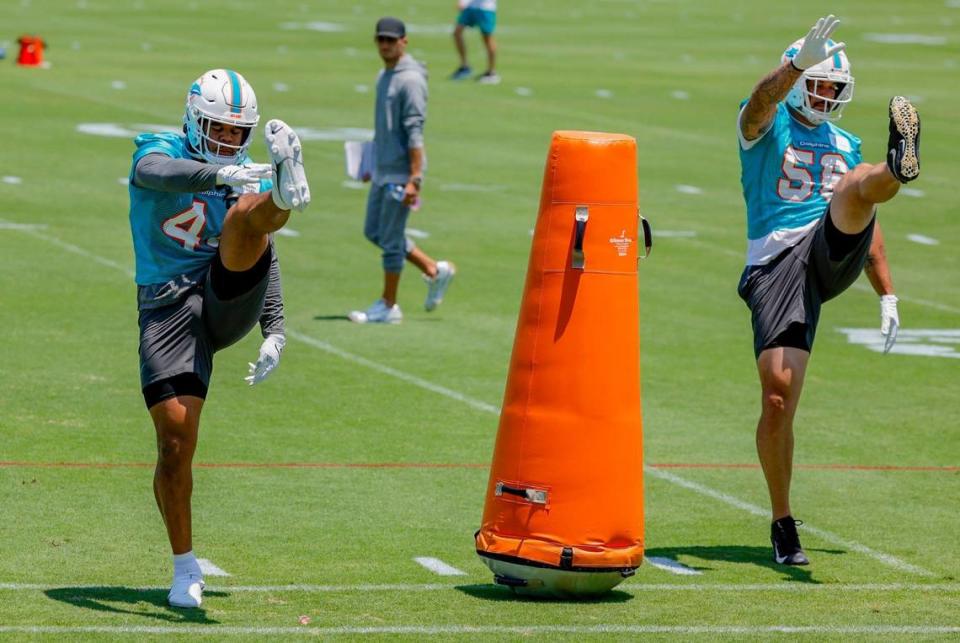 Miami Dolphins Chop Robinson (44) and Aaron Lynch (56) exercise as coach Mike McDaniel watches.