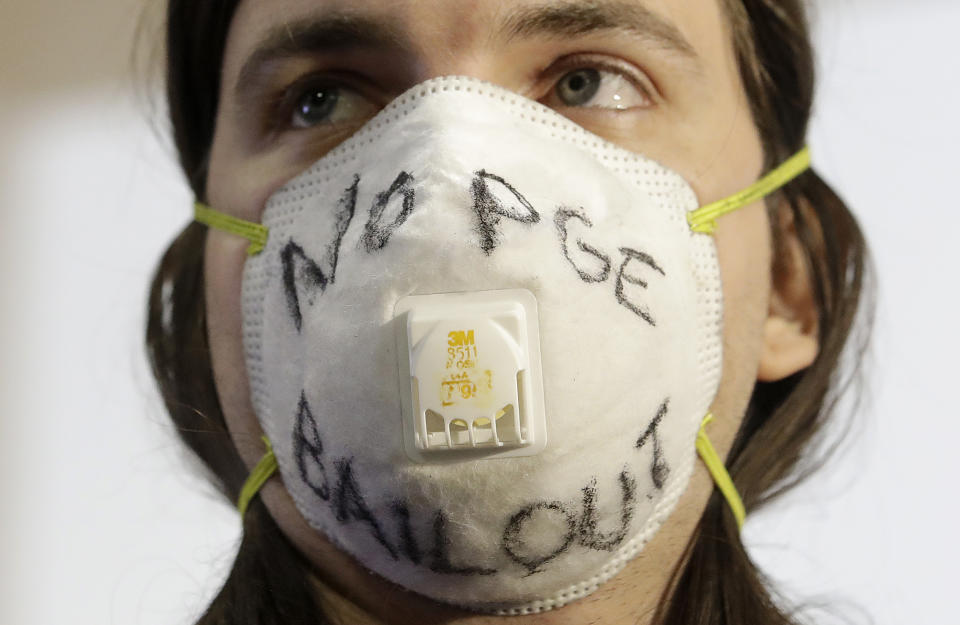 Protester J Redwoods with Mask Oakland is interviewed by media after a hearing at the Public Utilities Commission in San Francisco, Thursday, Nov. 29, 2018. California regulators have ordered the Pacific Gas & Electric Co. utility to significantly improve its "safety culture" after questioning the safety qualifications of top executives. California authorities are investigating whether PG&E's equipment started the wildfire on Nov. 8 in Paradise, Calif. (AP Photo/Jeff Chiu)