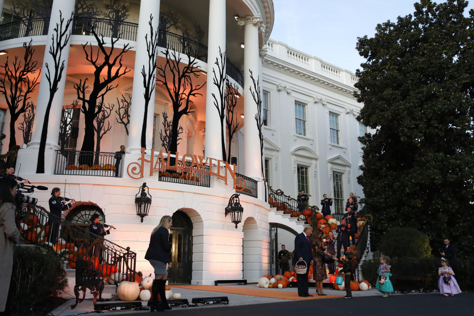 President Donald Trump and first lady Melania Trump give candy to children during a Halloween trick-or-treat event on the South Lawn of the White House which is decorated for Halloween, Monday, Oct. 28, 2019, in Washington. (AP Photo/Alex Brandon)