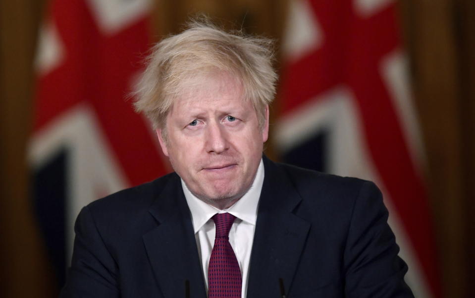 Britain's Prime Minister Boris Johnson speaks during a news conference in response to the ongoing situation with the coronavirus (COVID-19) pandemic, inside 10 Downing Street, London, Saturday, Dec. 19, 2020. Johnson says Christmas gatherings can’t go ahead and non-essential shops must close in London and much of southern England as he imposed a new, higher level of coronavirus restrictions to curb rapidly spreading infections. (Toby Melville/Pool Photo via AP)