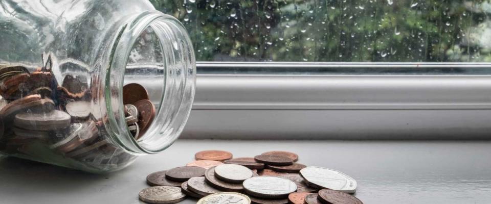 Jar of english money with rainy day background